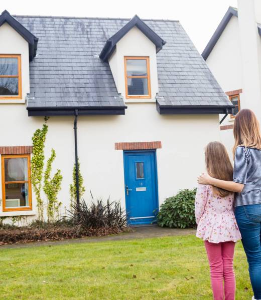 Mother and daughter standing in lawn